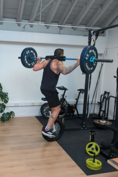 “Unicycle Strongman” rides back into record book by squatting over 130 lbs mid-peddle